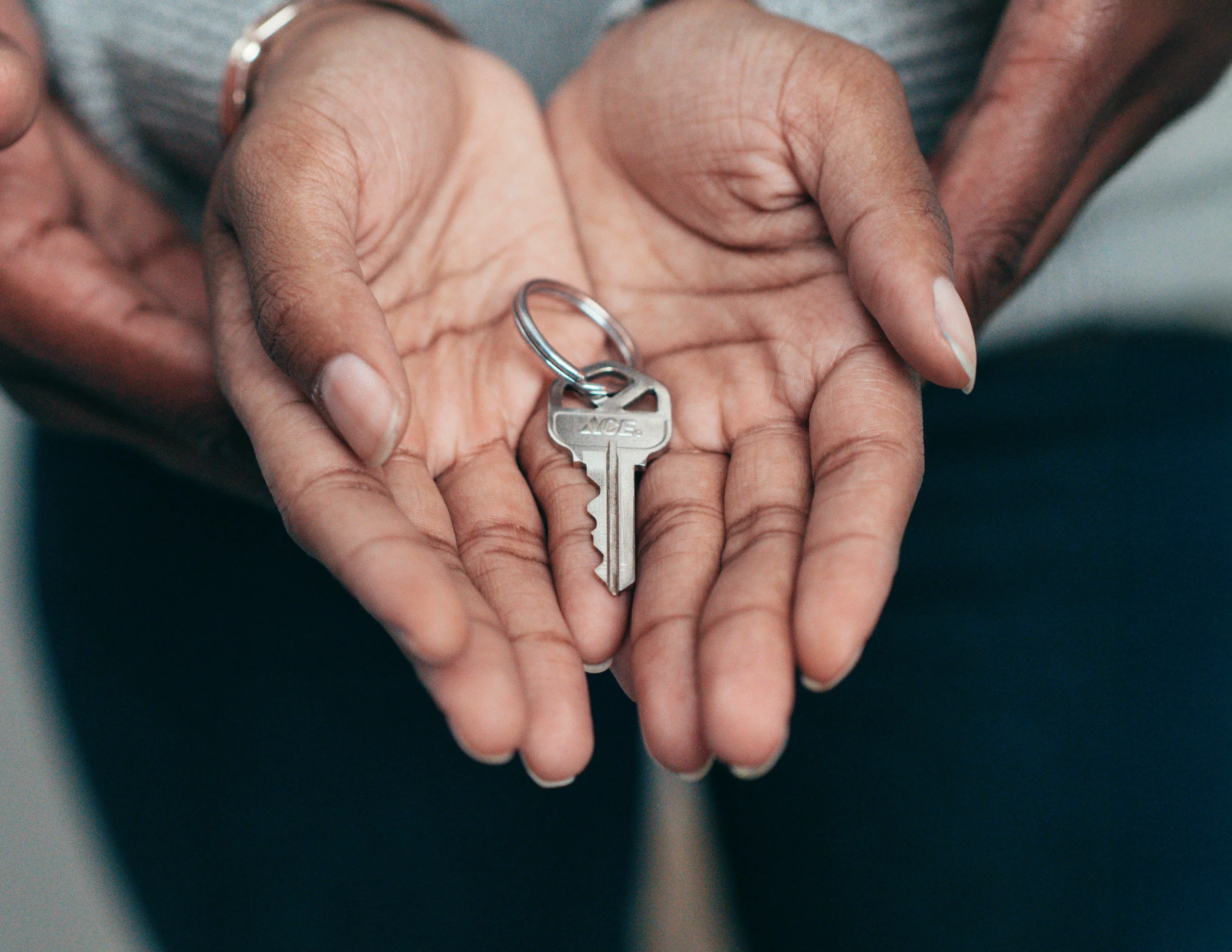 Heir reviewing inherited property documents with house keys and deed paperwork in California